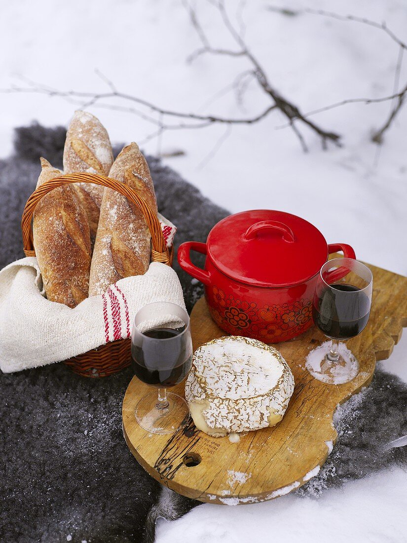 Winter-Picknick mit Eintopf, Käse, Brot und Wein