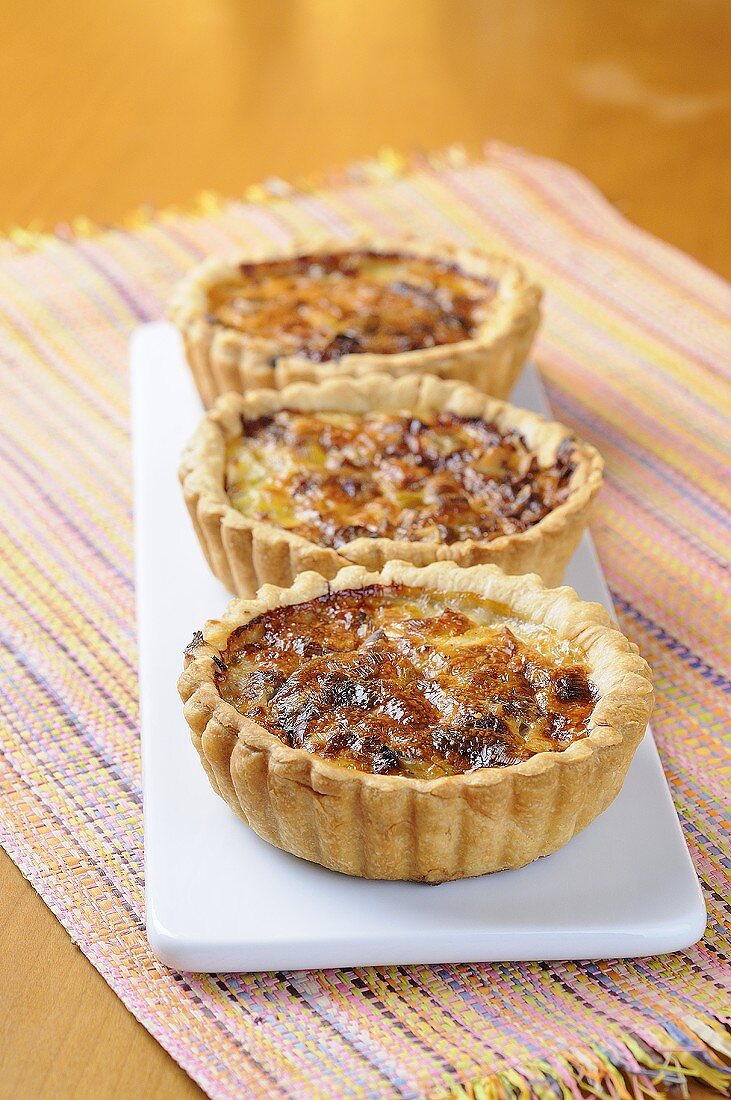 Three individual cheese and leek quiches