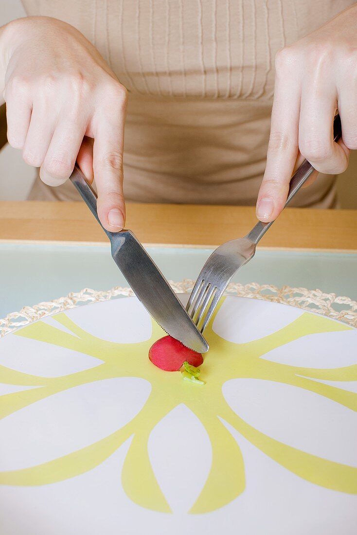 Eating a radish with a knife and fork