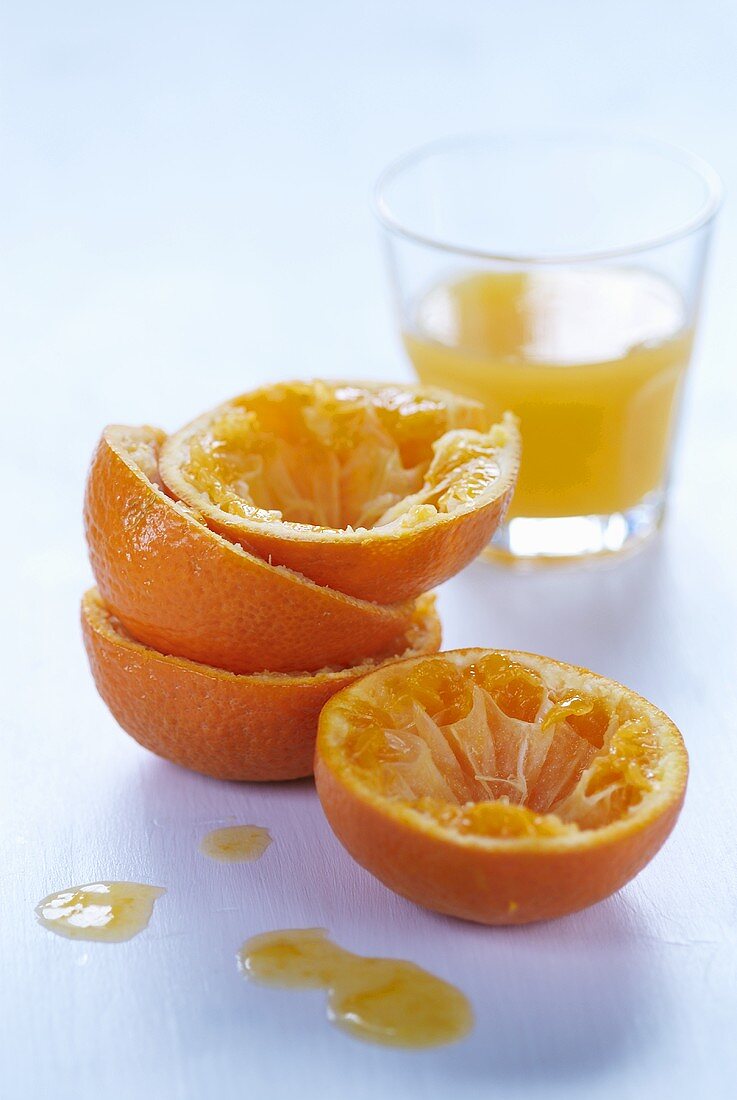 Ausgepresste Orangenhälften und frisch gepresster Orangensaft