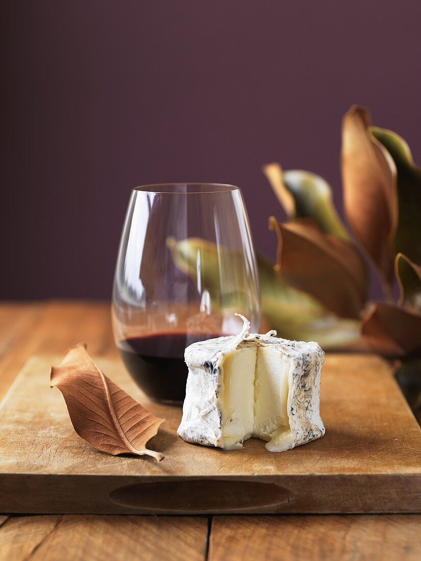 Herbstliches Stillleben mit Weichkäse und Rotwein