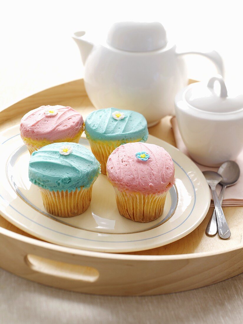 Cupcakes mit Zuckercreme und -blüten zum Tee