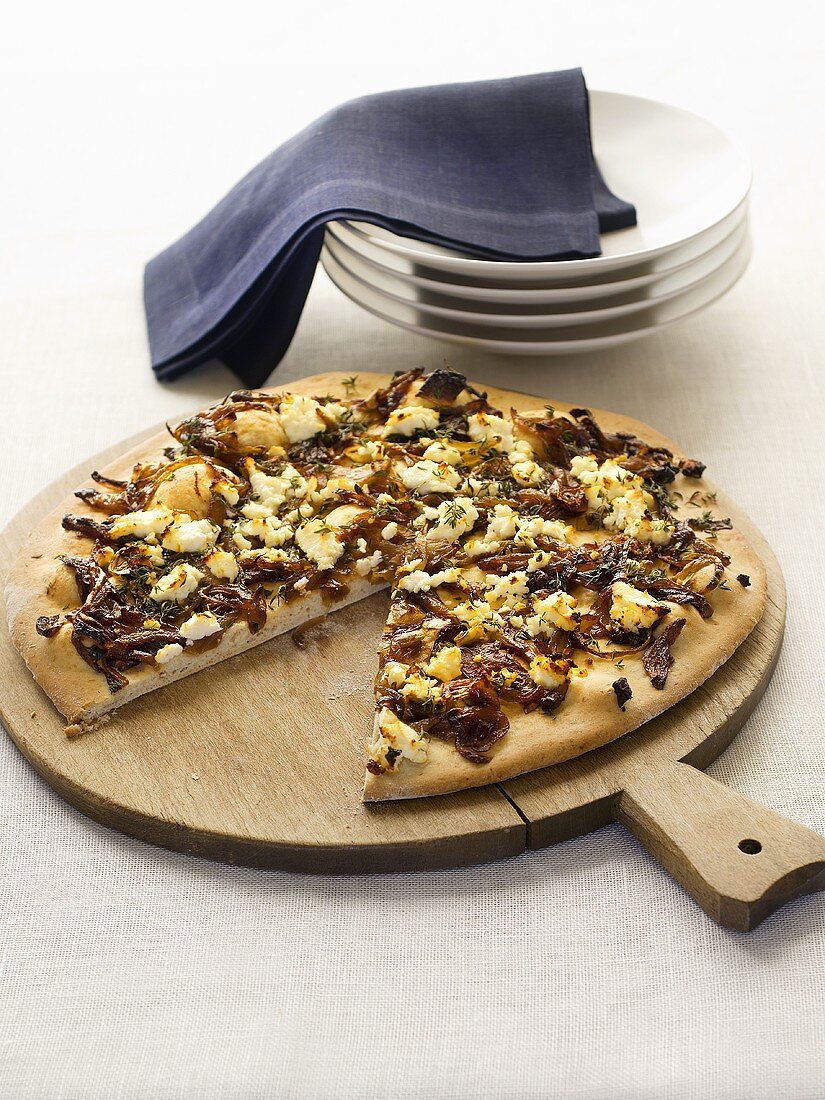 Pizza topped with caramelised onions, a slice removed