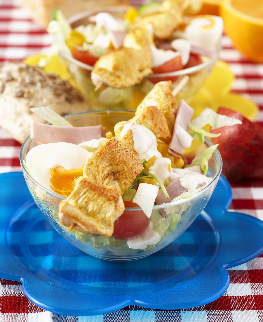 Chicken skewer on salad with egg