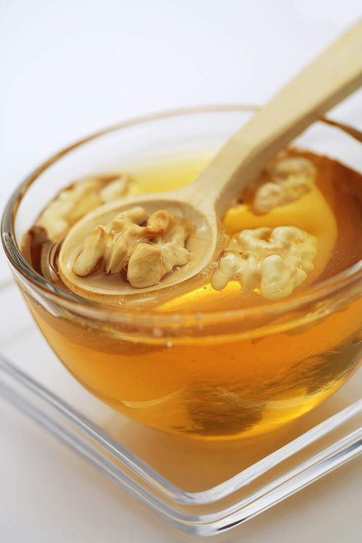 Honey with walnuts in glass bowl