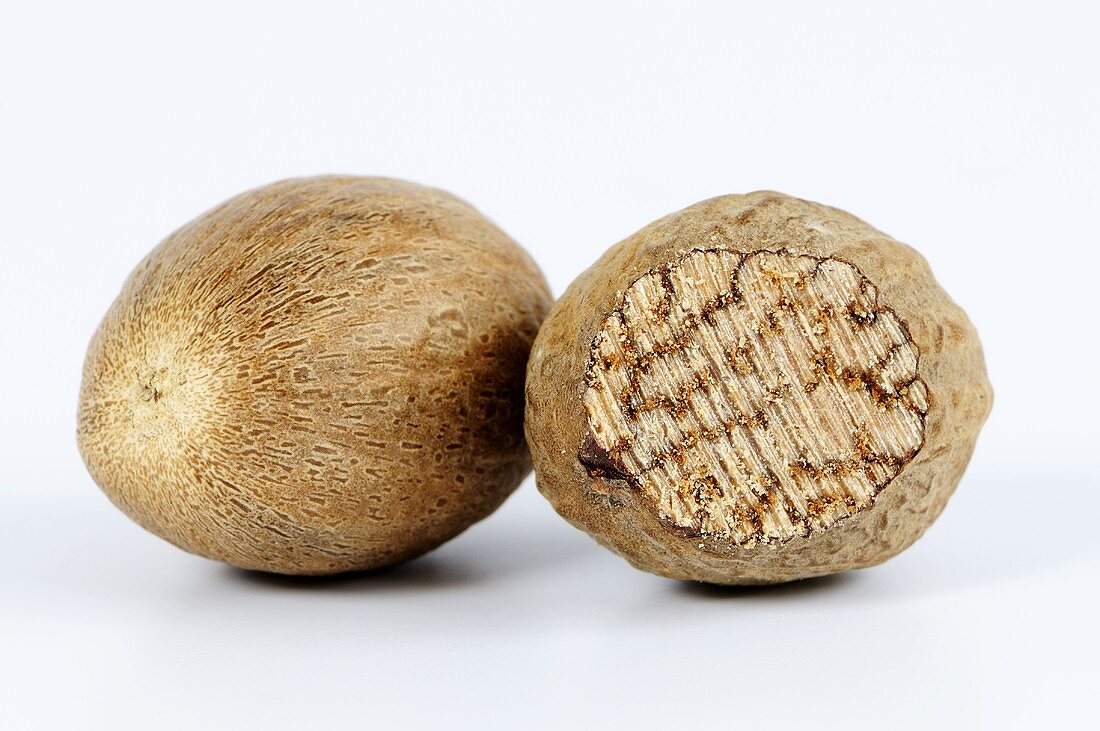 Whole nutmeg and half of a nutmeg