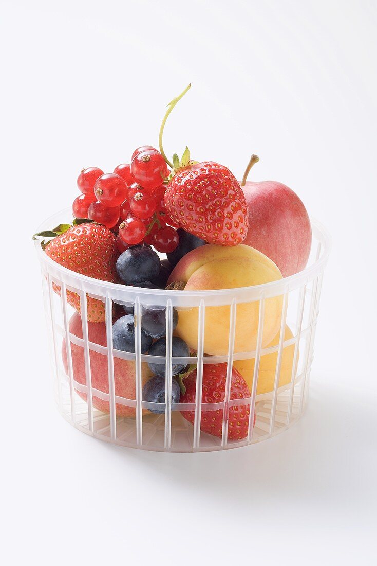 Fruit and berries in a plastic basket