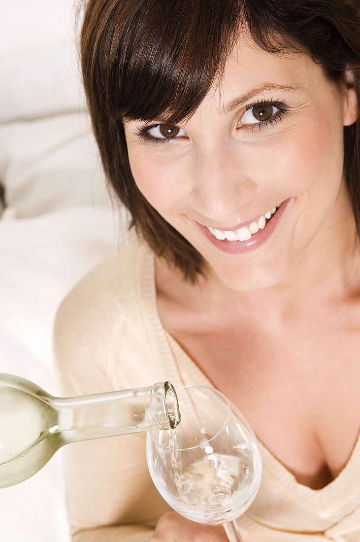 Woman having a glass of white wine poured