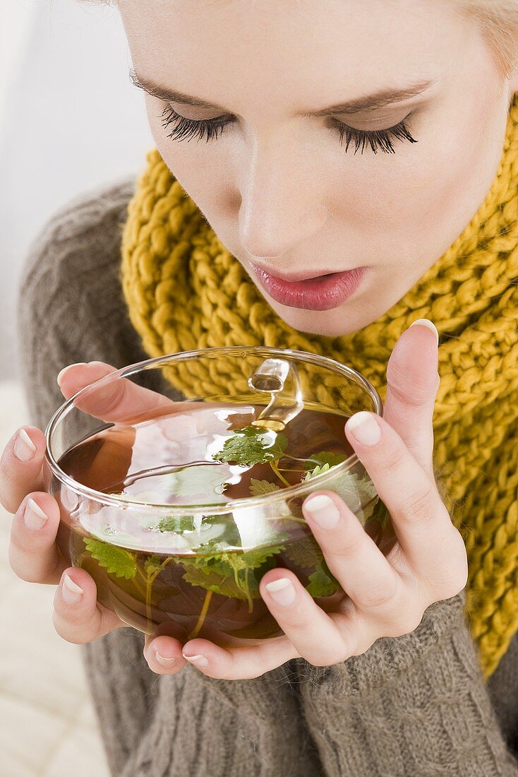 Junge Frau trinkt Kräutertee