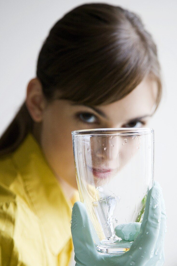 Young woman washing a glass