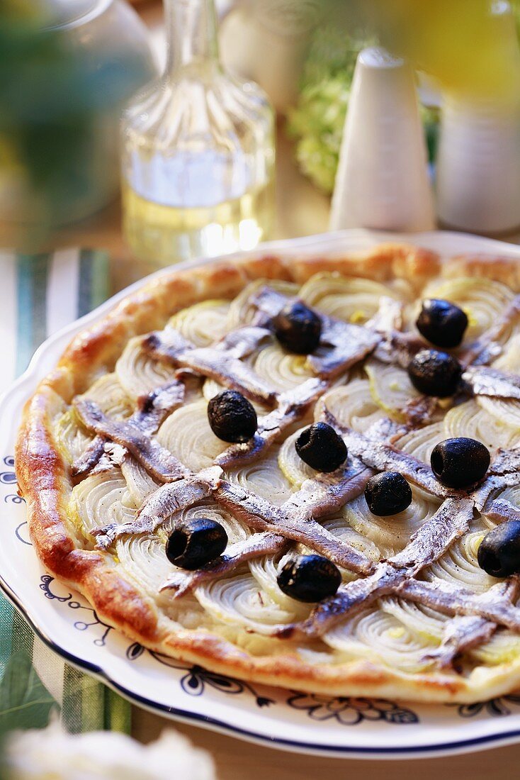 Eine Zwiebelpizza mit Sardellen und schwarzen Oliven
