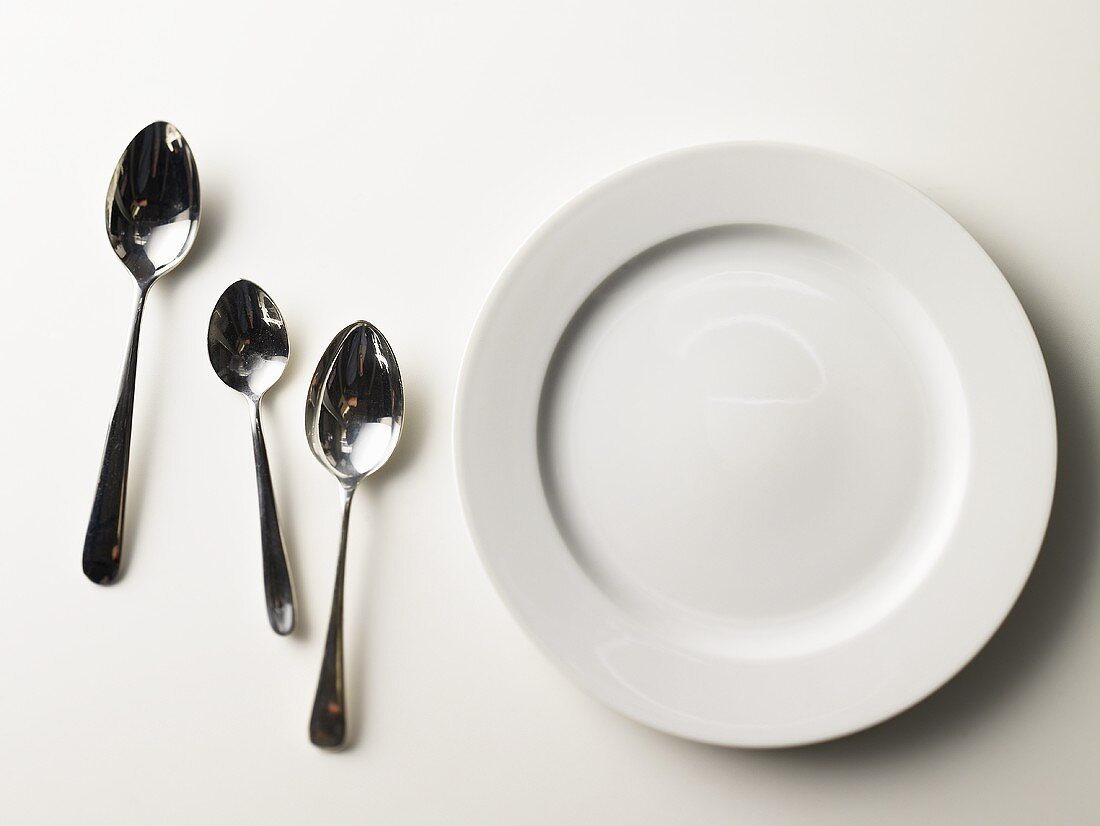 Empty plate with three spoons