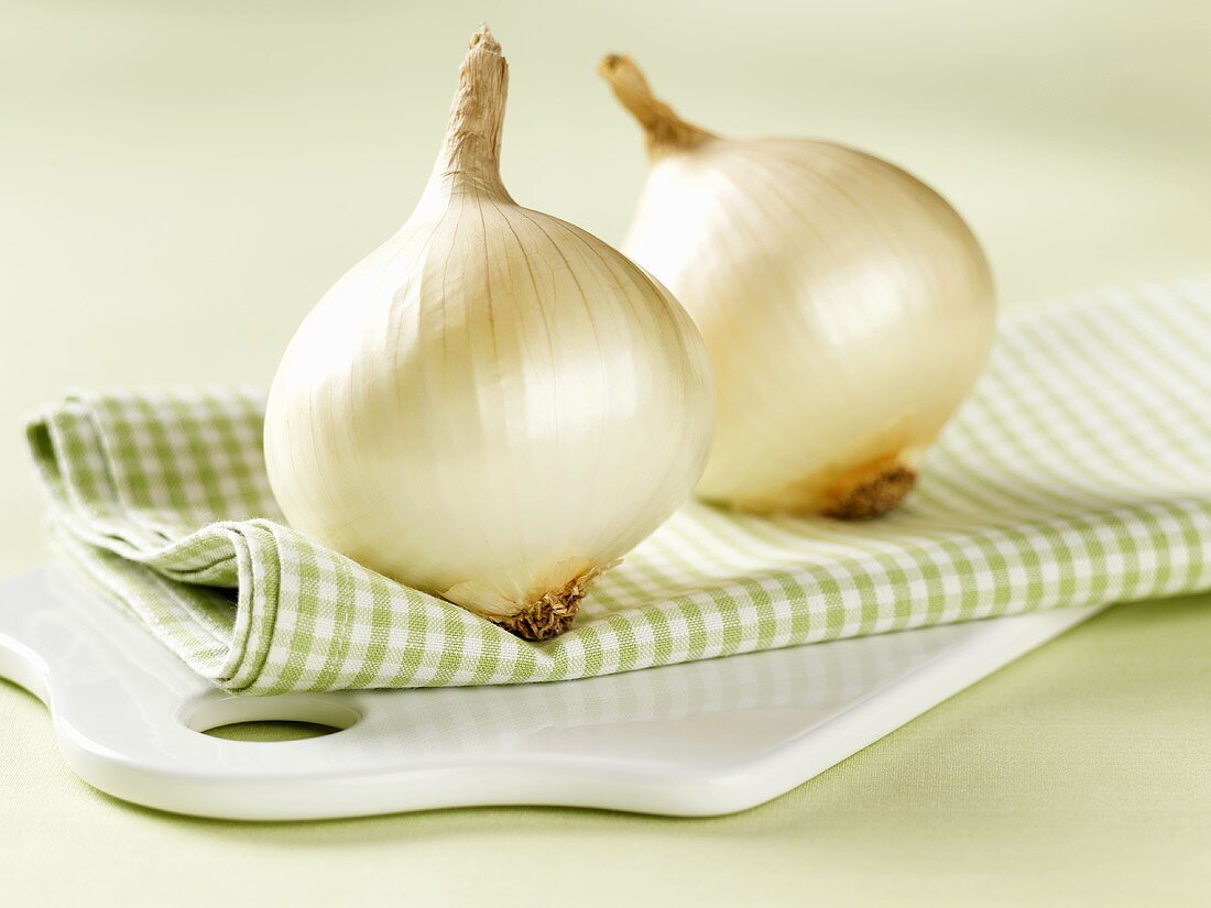 Two white onions on checked cloth