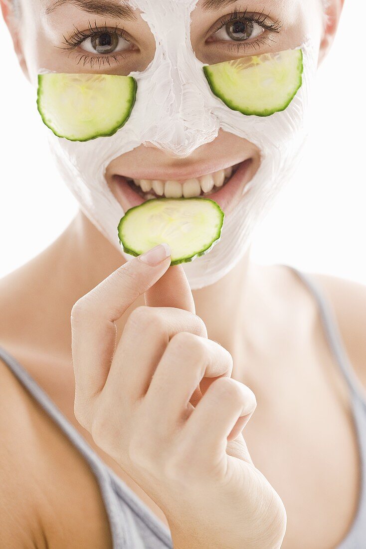 Young woman with cucumber facial mask