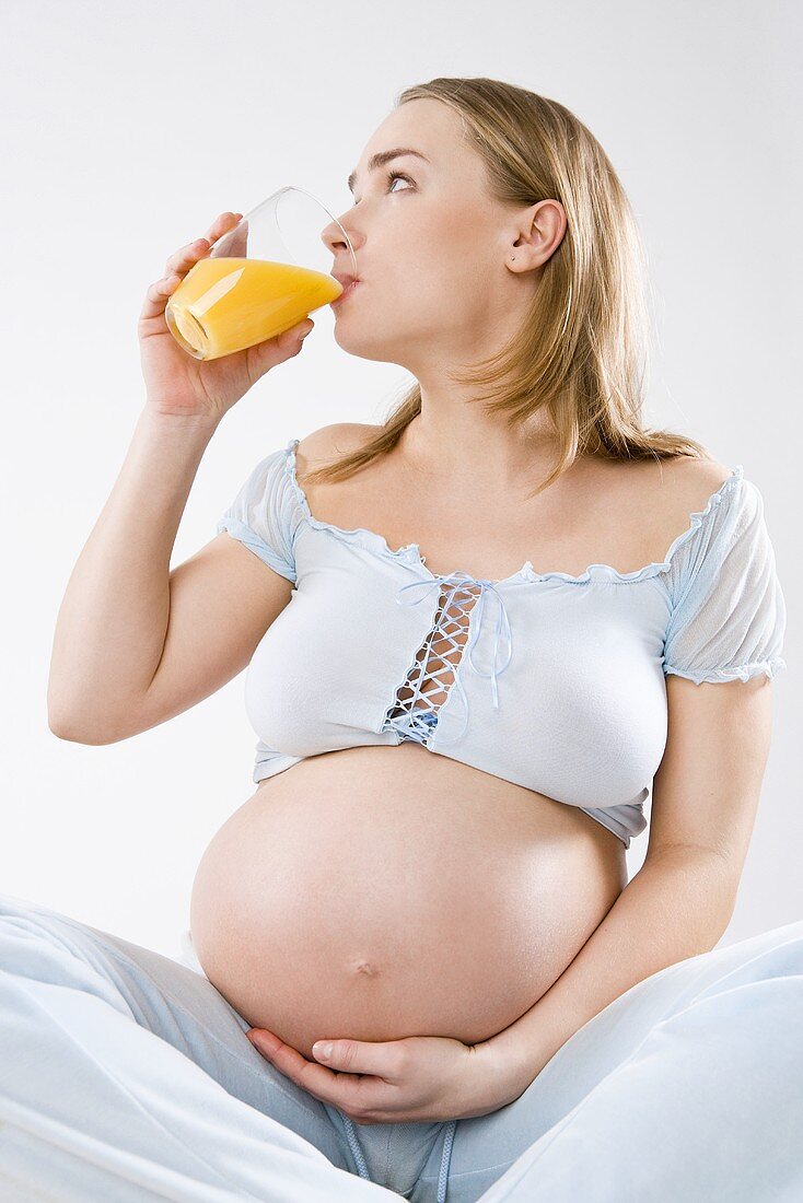 Pregnant woman drinking orange juice