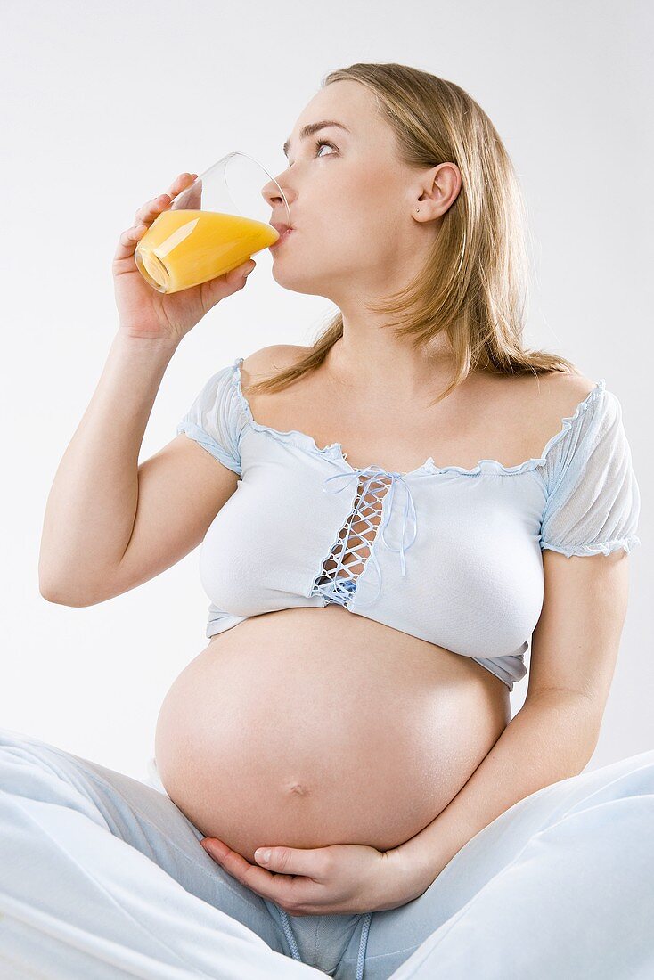 Schwangere Frau trinkt Orangensaft