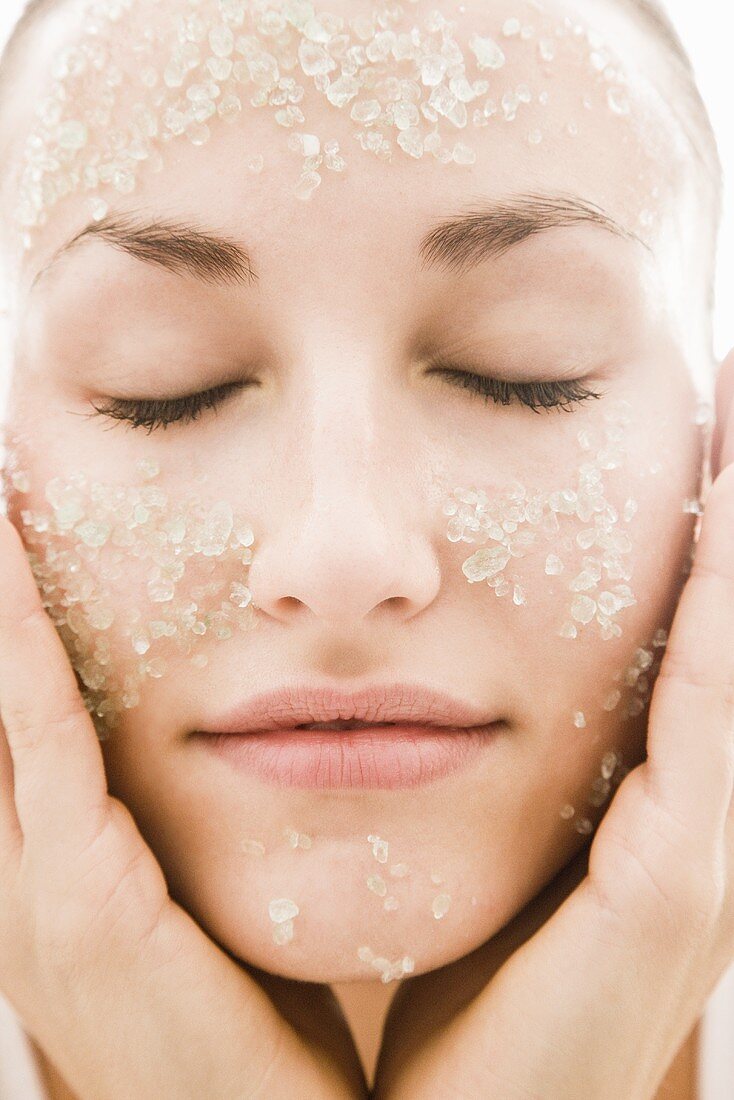 Young woman with exfoliating scrub on her face