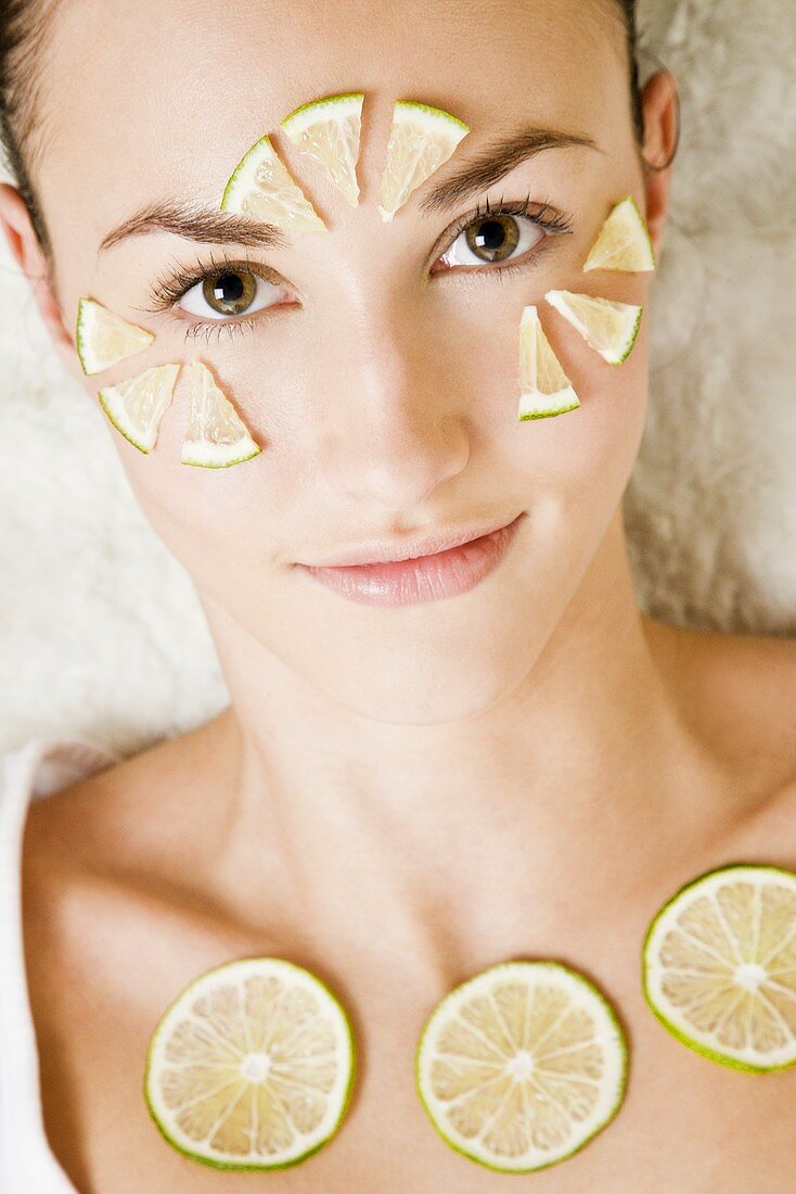 Woman with lime slices on her face and neckline