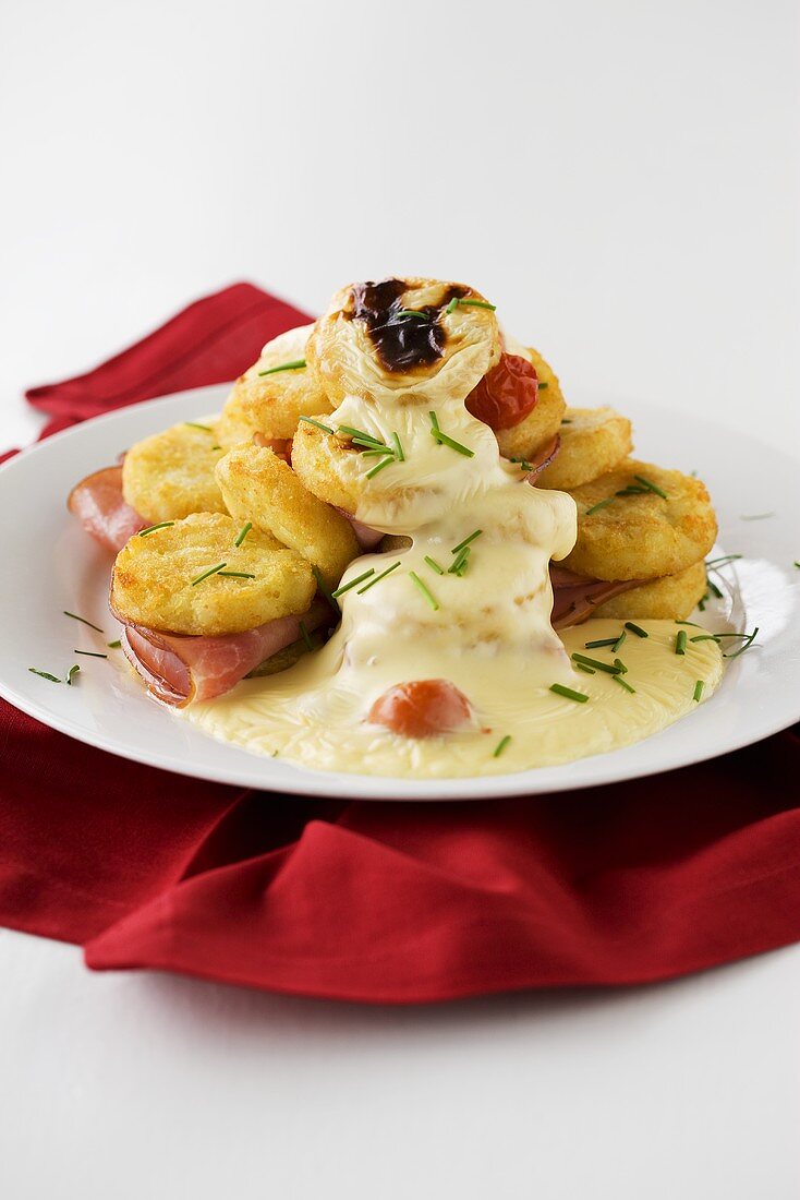 Potato cakes and smoked ham with cheese sauce