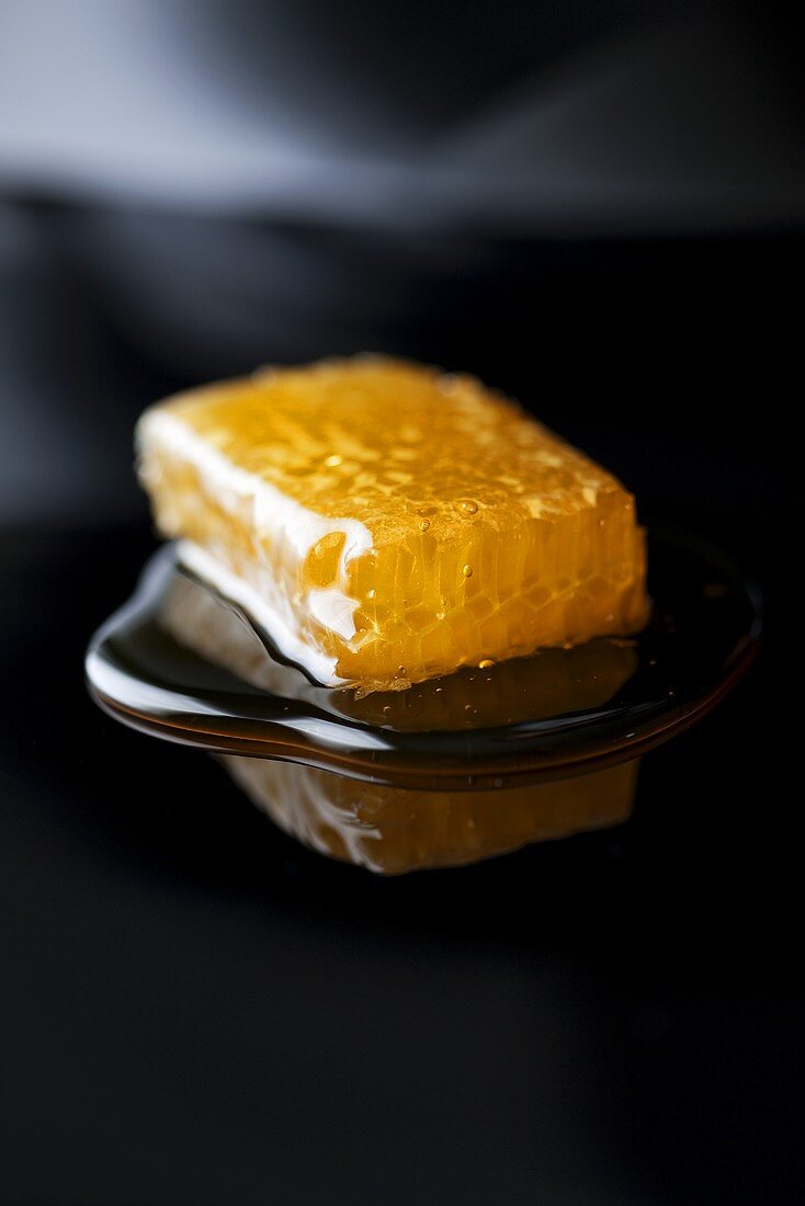 Honeycomb with honey on reflective surface