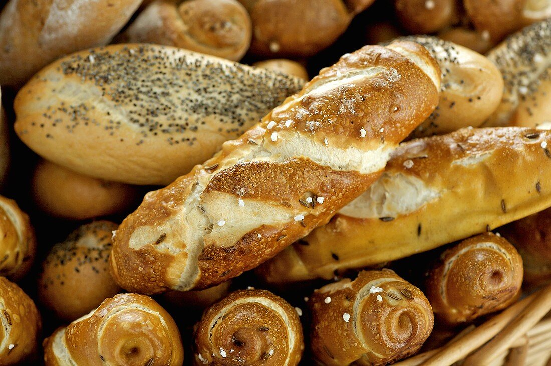 Pretzel rolls & poppy seed rolls in bread basket (close-up)