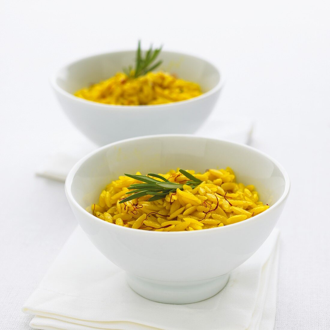 Two bowls of saffron rice with rosemary