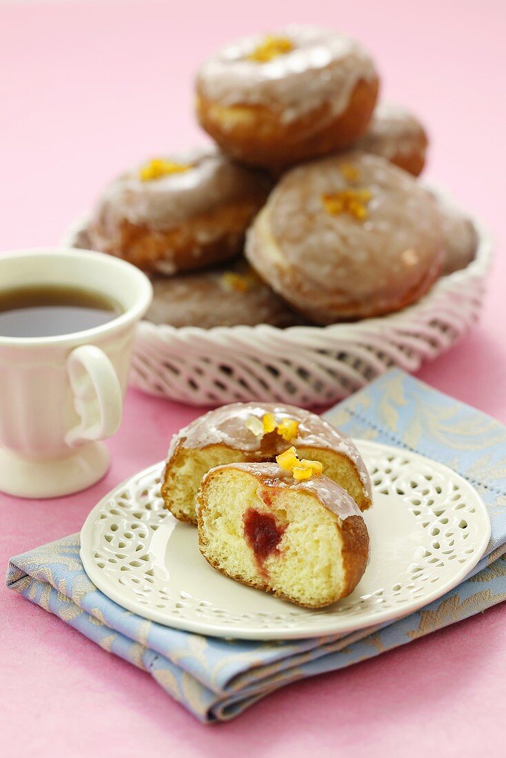 Donuts mit Konfitürenfüllung und Zuckerglasur zum Tee