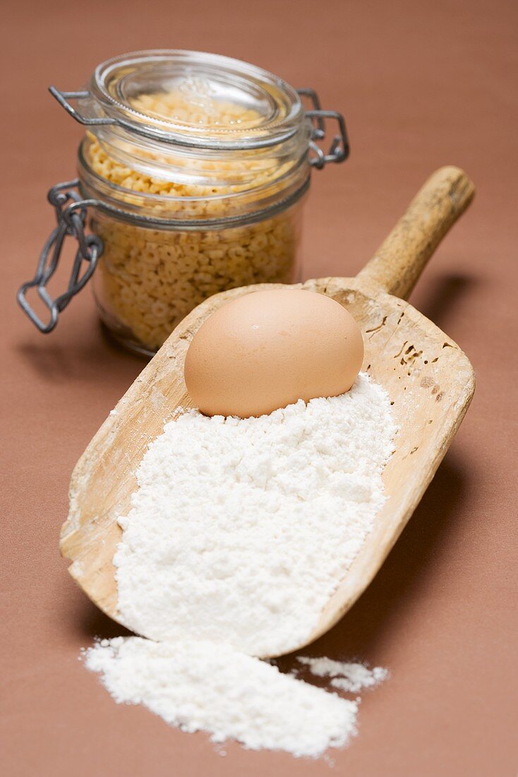 Flour and egg in old flour scoop, egg pasta in jar
