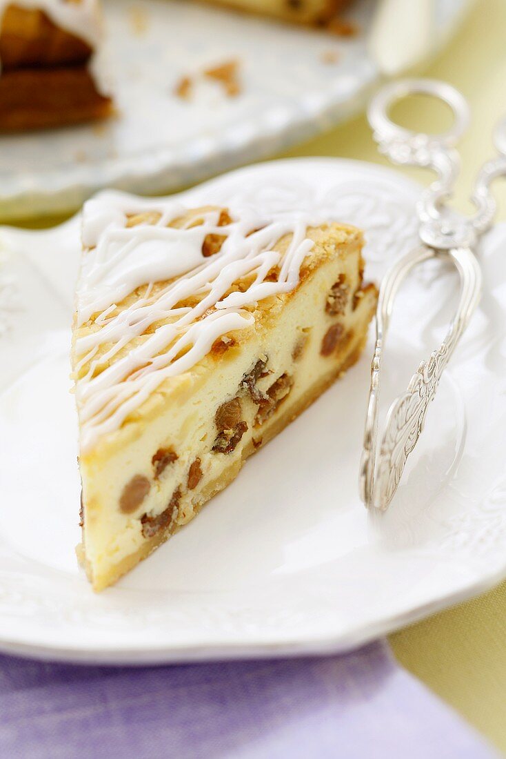 A piece of iced cheesecake with raisins