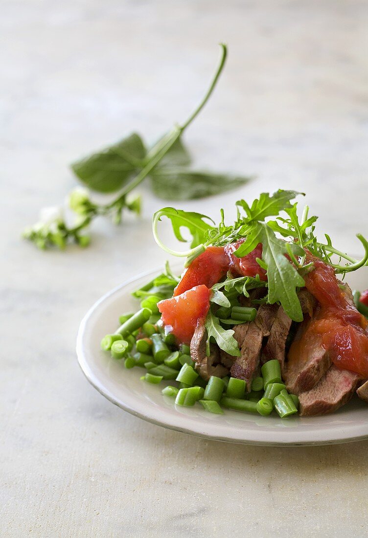 Rindermedaillons auf Bohnensalat mit Tomaten und Rucola