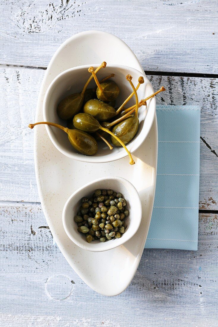 Capers and caper berries in small bowls
