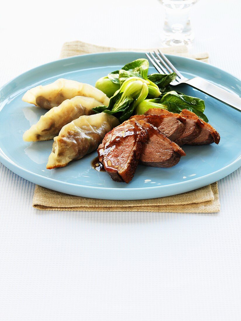Duck breast with filled dumplings and baby pak choi