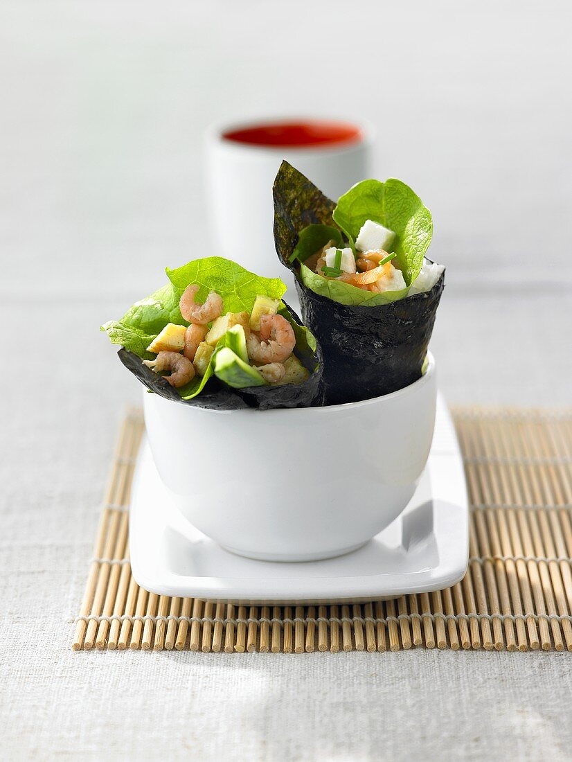 Zwei verschiedene Temaki-Sushi mit Shrimps und Räucherlachs
