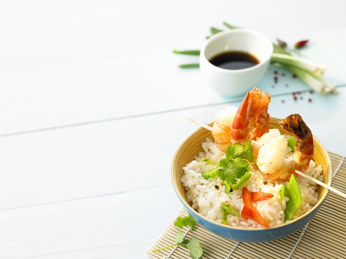 Rice with skewered prawns, vegetables and coriander