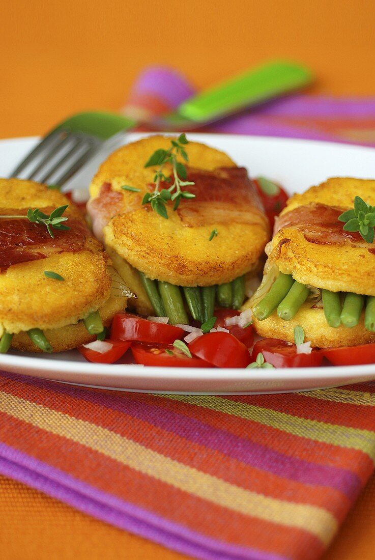 Fried polenta slices with beans, bacon and tomatoes