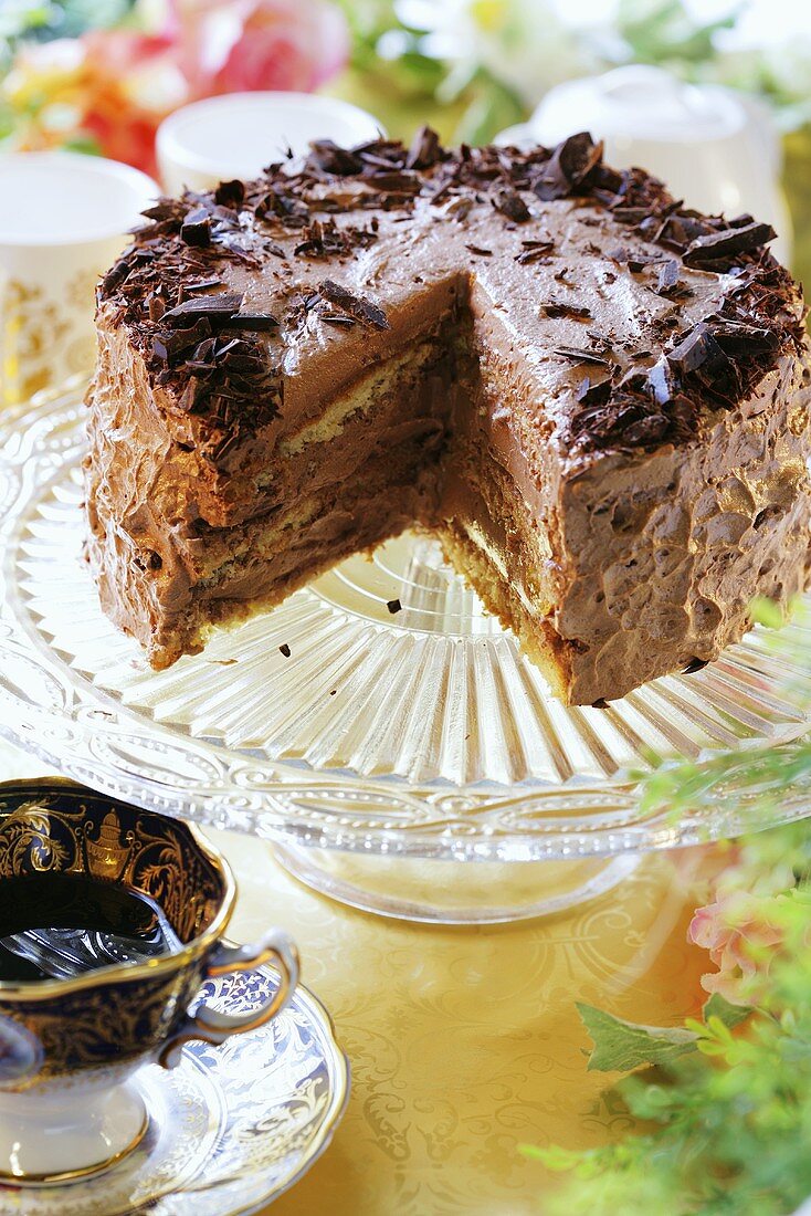 Rum chocolate cake, a piece removed, on cake stand
