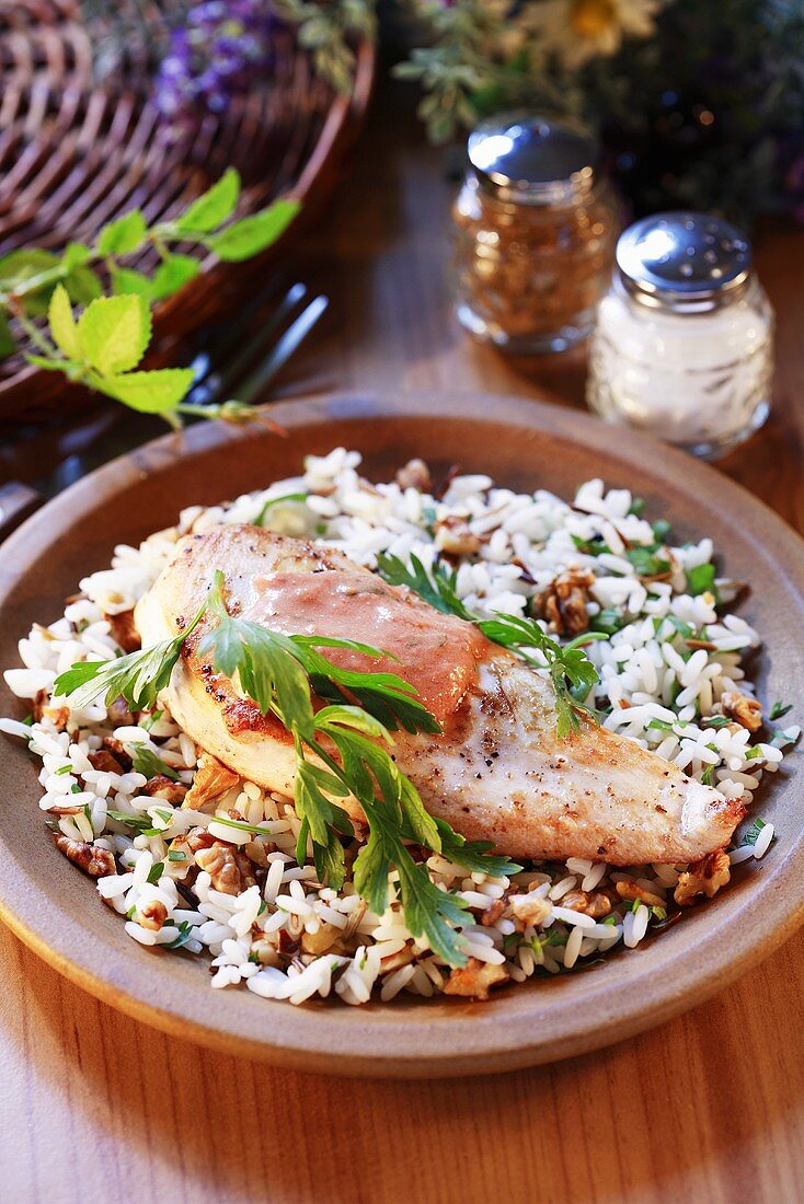 Chicken breast on rice with nuts and herbs