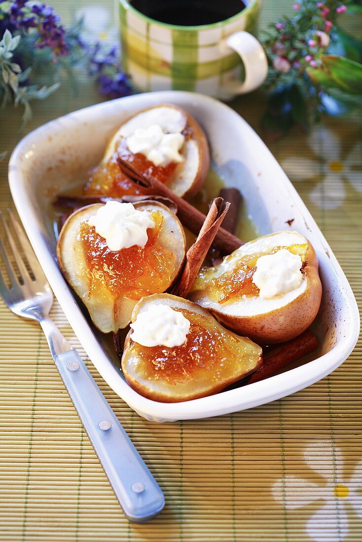 Pears with orange marmalade, cream and cinnamon sticks
