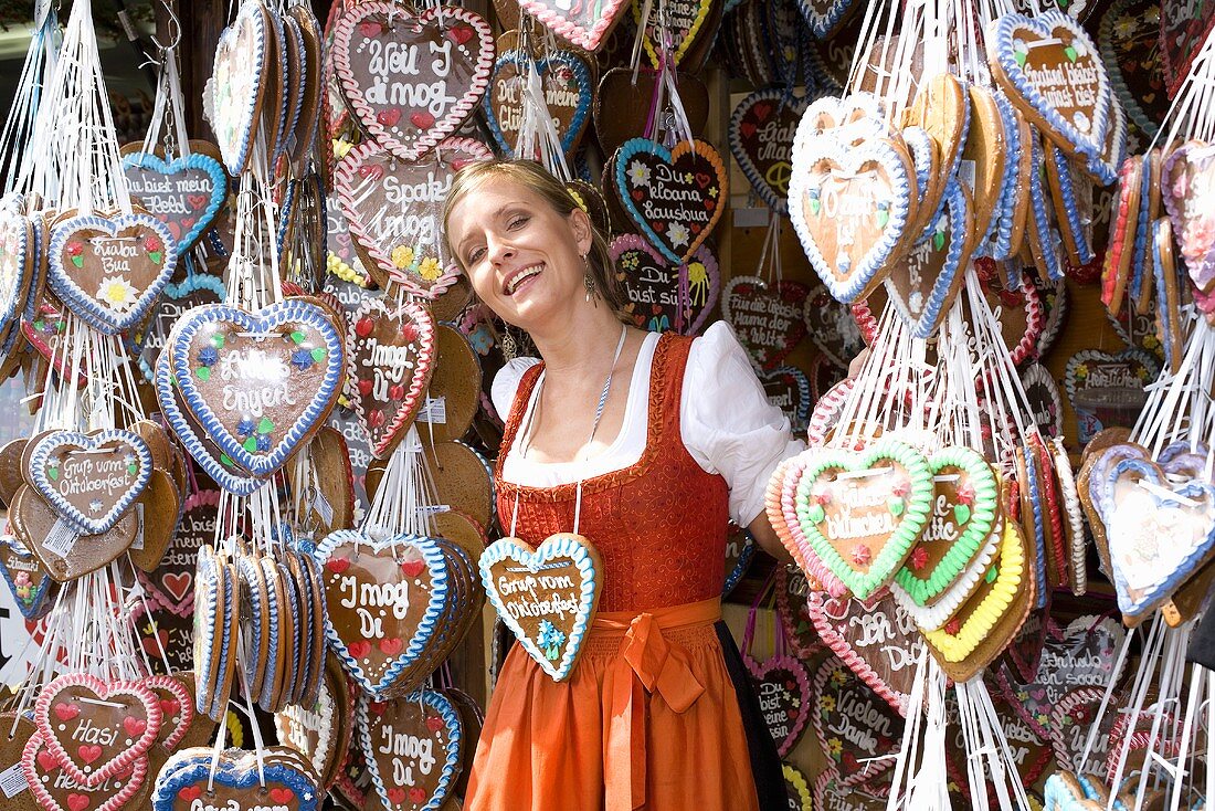 Frau im Dirndl am Stand mit Lebkuchenherzen (Oktoberfest)