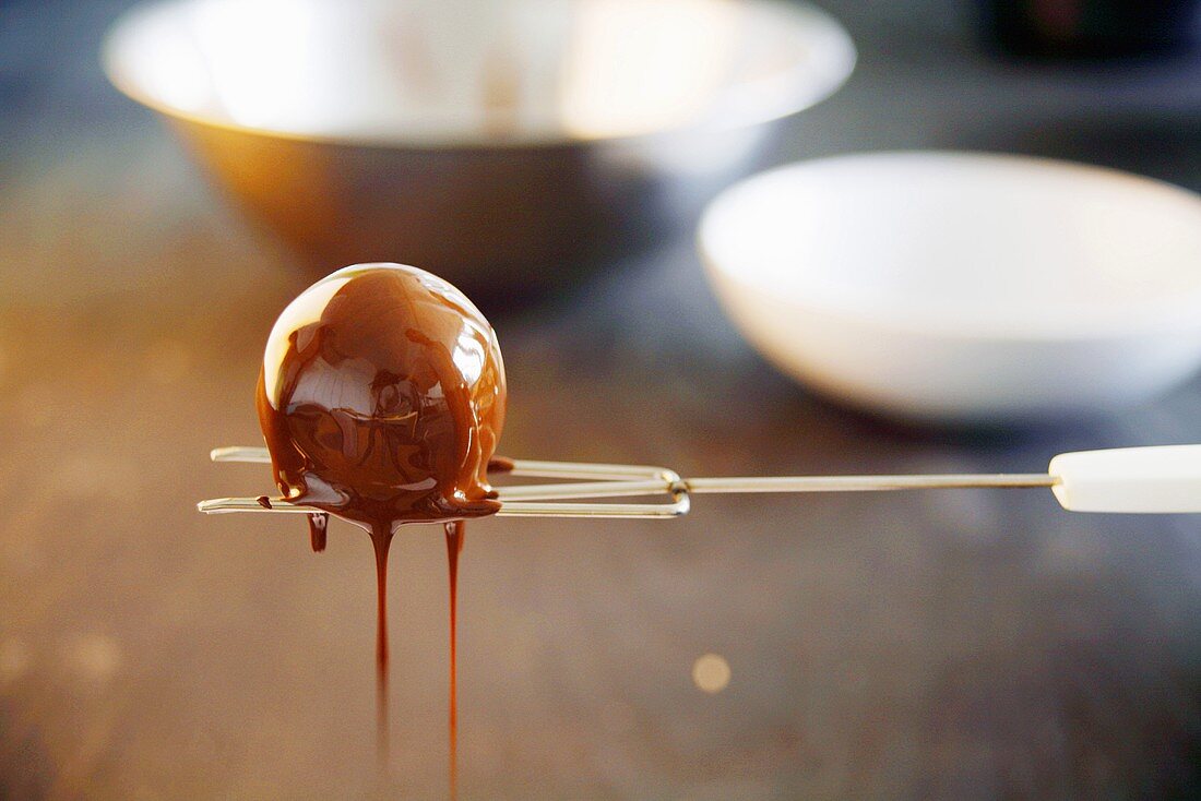 Chocolate truffle draining on chocolate fork