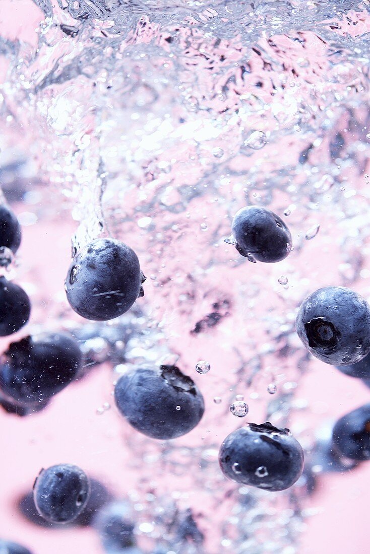 Blueberries falling into water