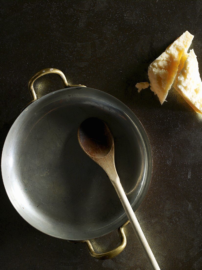 Frying pan with wooden spoon and Parmesan