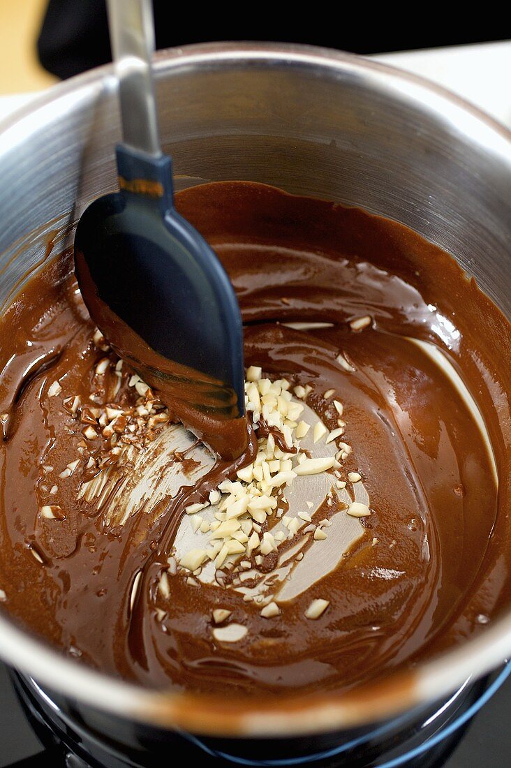 Mandelstifte mit geschmolzener Schokolade verrühren (Zubereitung von Schokoladenbiscotti)
