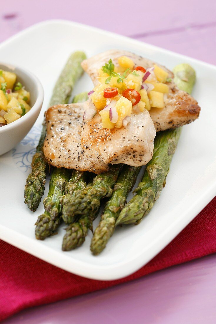 Chicken breast on asparagus with chilli mango salsa