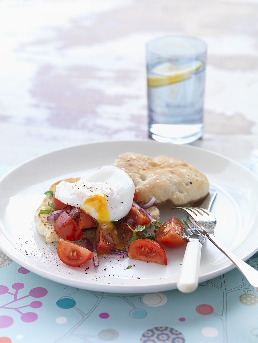 Tomato salad, poached egg and onion on toasted bread