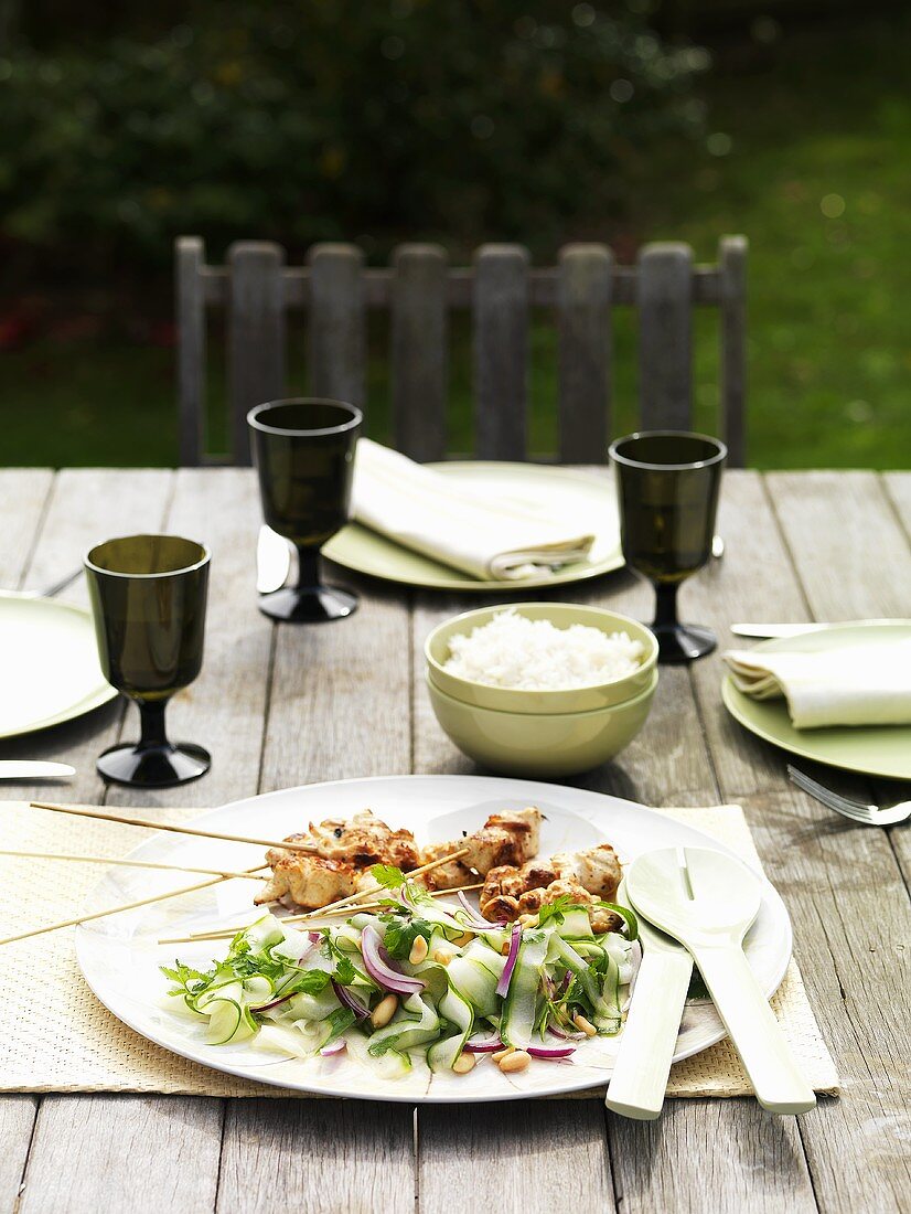 Thailändischer Gurkensalat mit Satespiessen im Freien