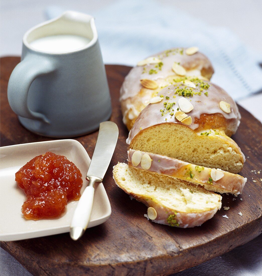 Bread plait with apricot jam and jug of milk