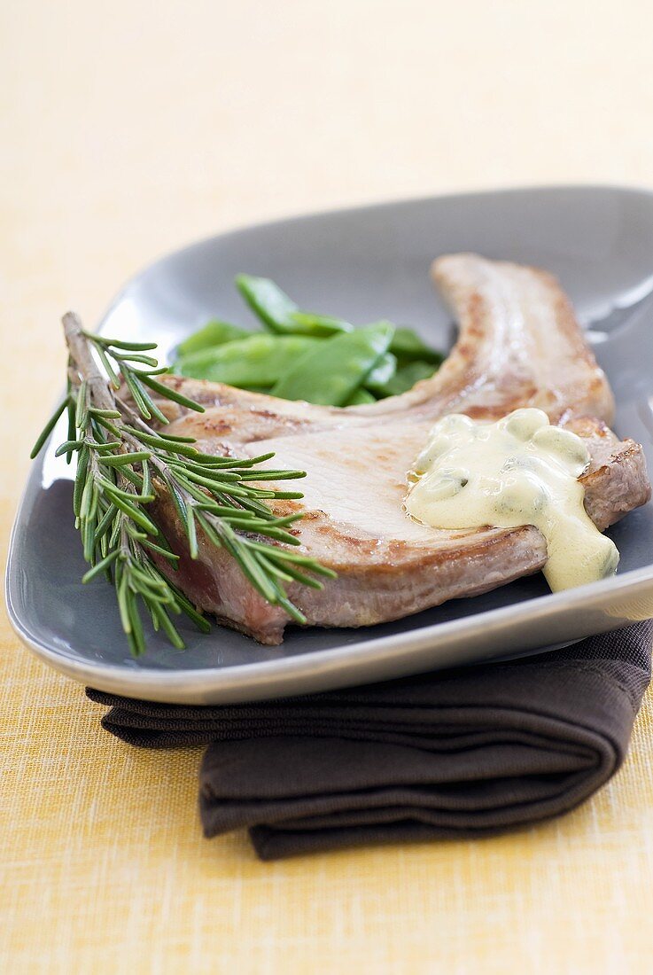 Pork chop with mustard sauce, rosemary and mangetout