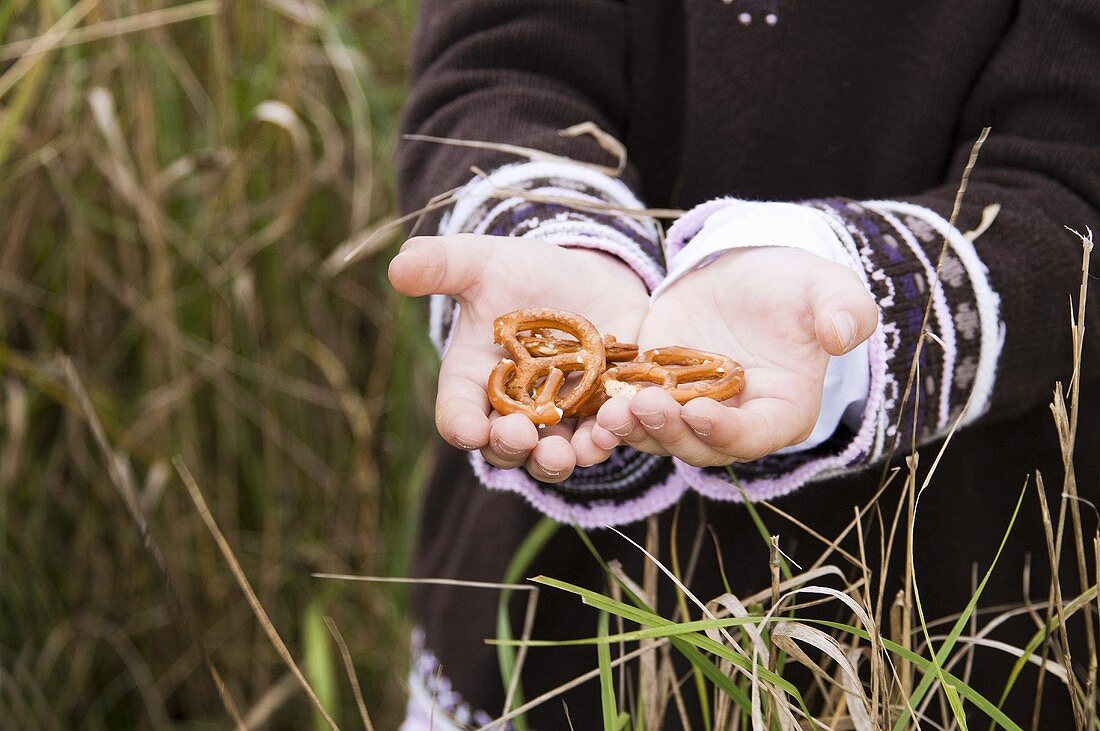 Child's hands holding salted pretzels