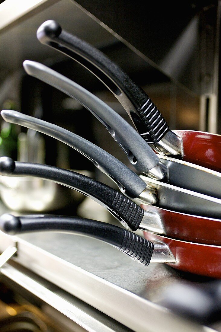 Stacked frying pans in a restaurant kitchen